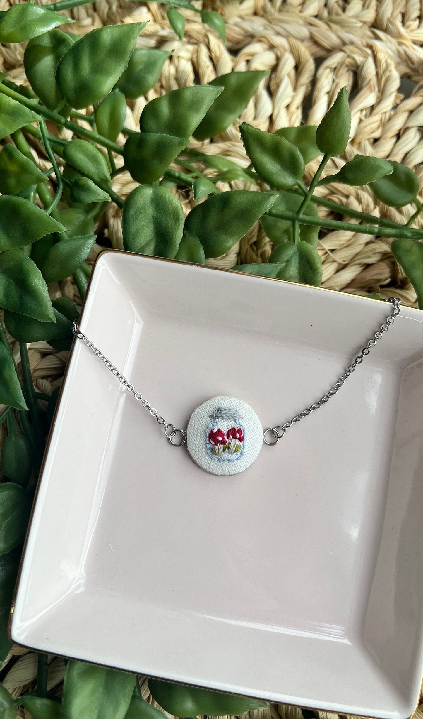 Embroidered mushroom in a jar set in a round bezel silver bracelet