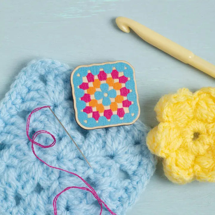 Wooden needle minder in the shape of a crochet granny square