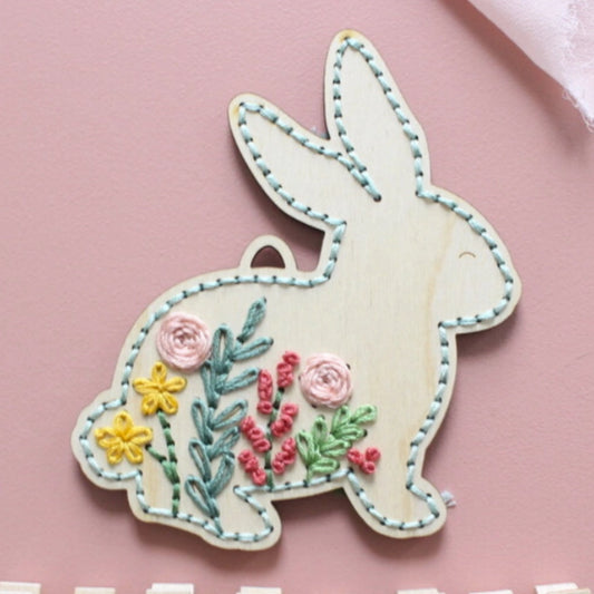 Embroidered bunny with flowers on a pink background