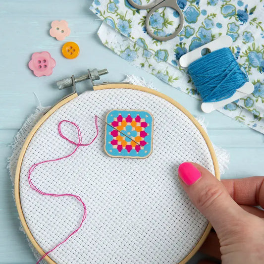 Wooden needle minder in the shape of a crochet granny square