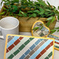 Striped rectangular mosaic coaster in deep red, blue, green, gray and ivory in a wood base with light gray grout