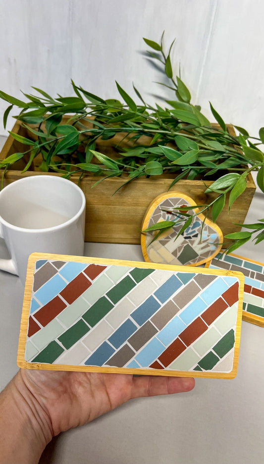 Striped rectangular mosaic coaster in deep red, blue, green, gray and ivory in a wood base with light gray grout