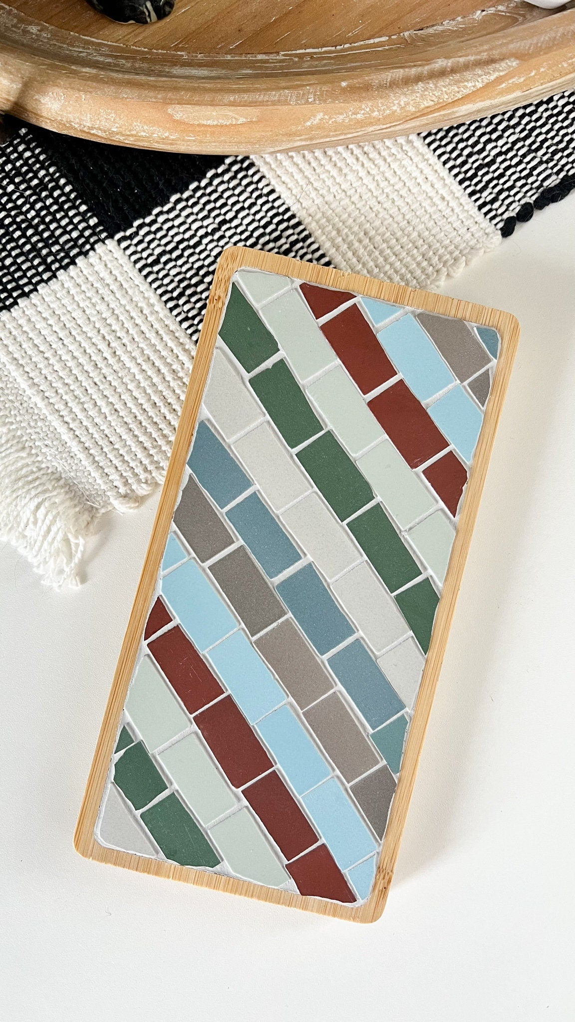 Striped rectangular mosaic coaster in deep red, blue, green, gray and ivory in a wood base with light gray grout