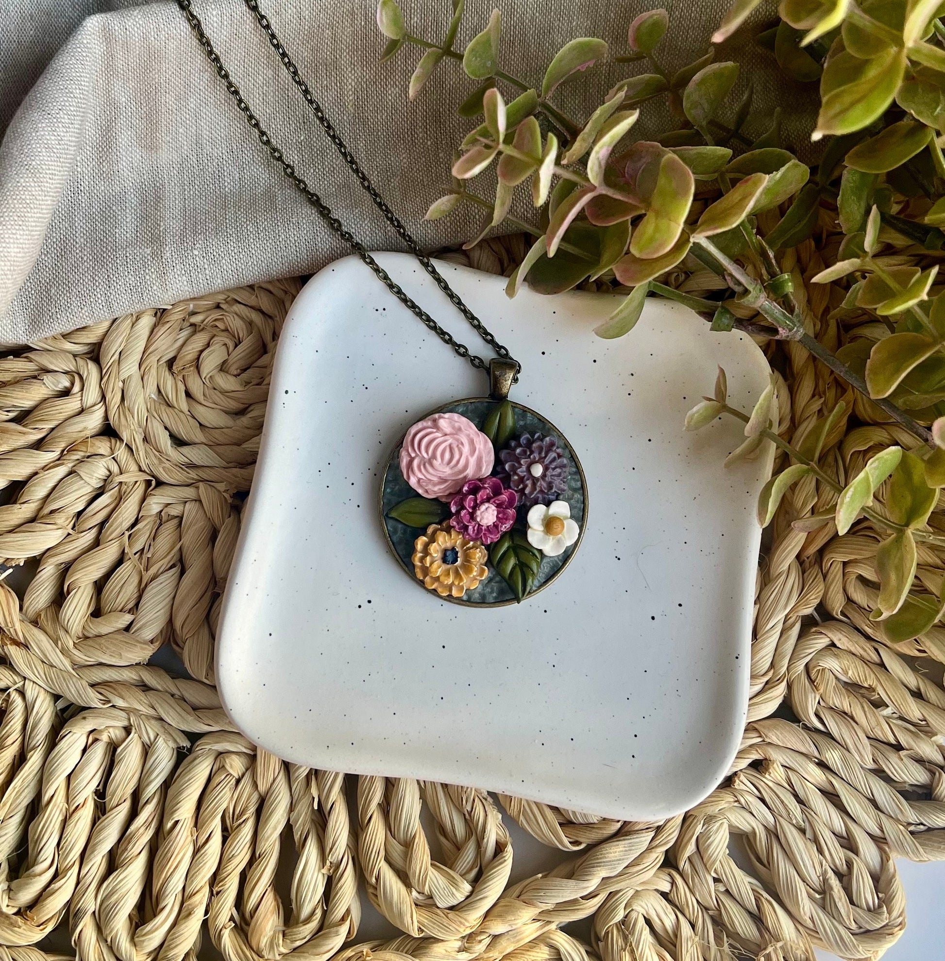 Polymer Clay pink yellow gray white floral pendant necklace in a round bronze bezel