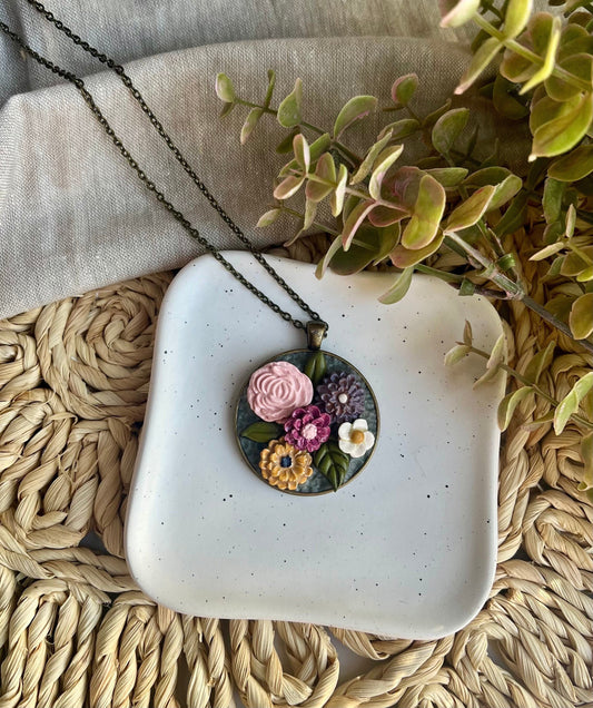 Polymer Clay pink yellow gray white floral pendant necklace in a round bronze bezel