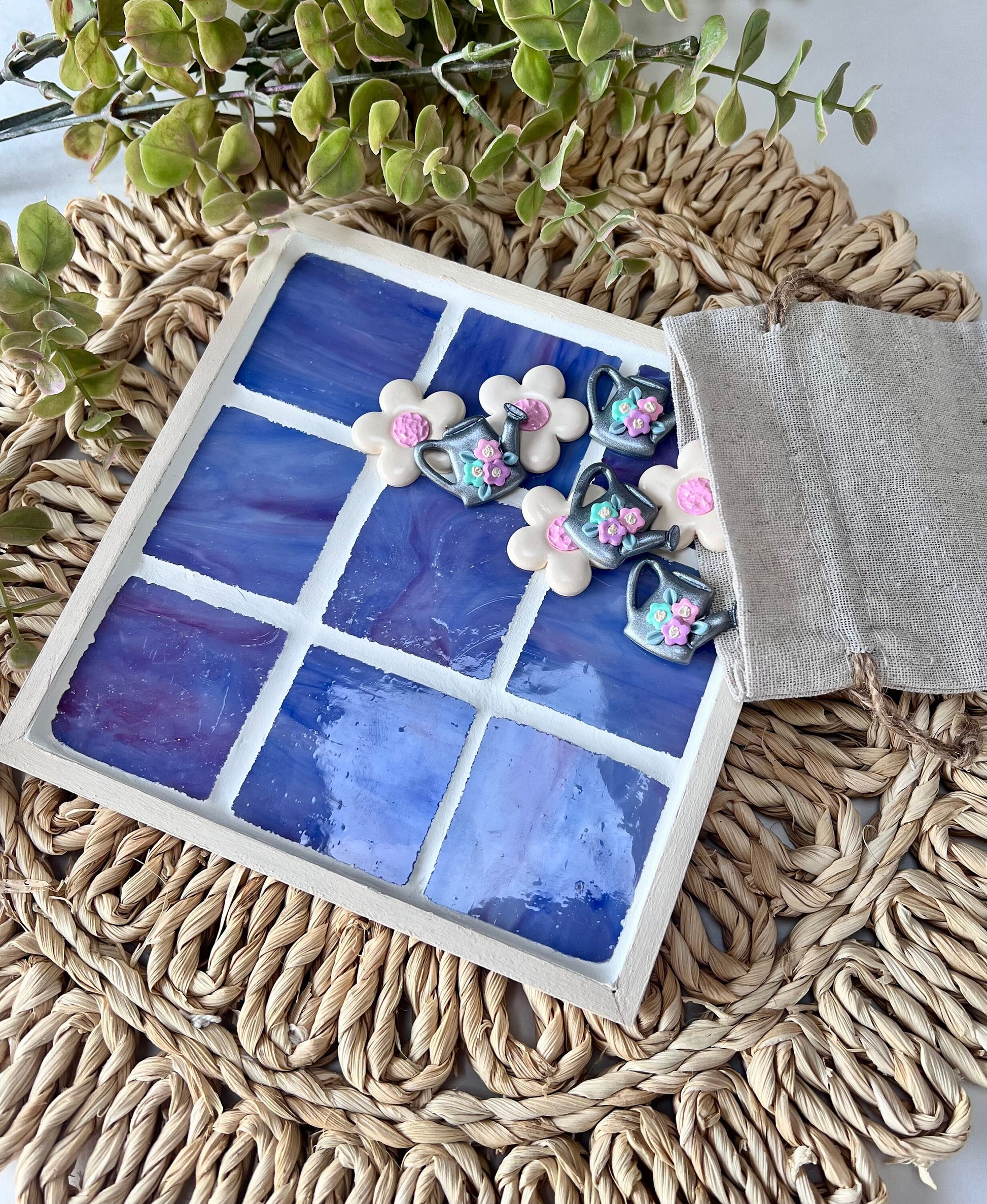 Stained glass tic tac toe board with watering can and daisy playing pieces