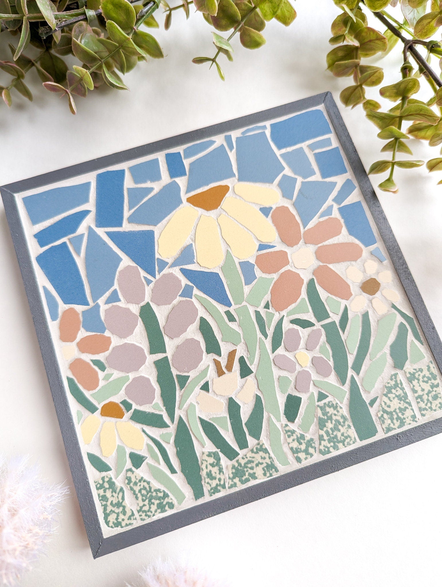 Floral mosaic set in a gray wooden frame featuring spring flowers in lavender, pink, yellow and off white