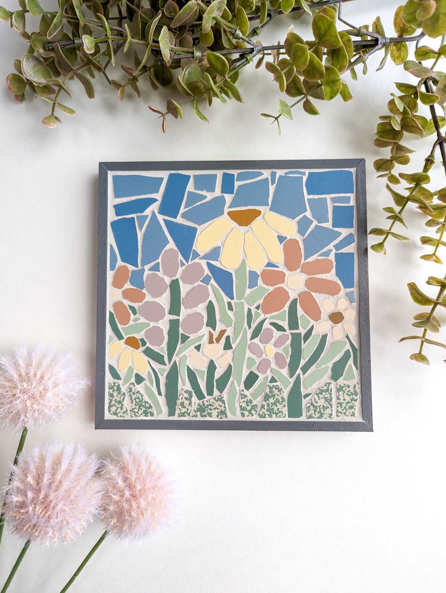 Floral mosaic set in a gray wooden frame featuring spring flowers in lavender, pink, yellow and off white