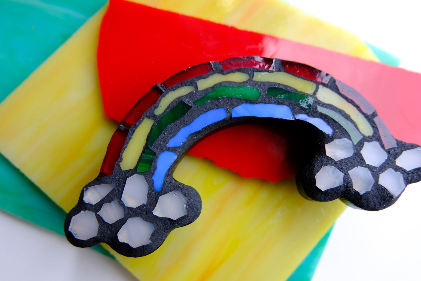 Stained glass mosaic rainbow with clouds and black grout