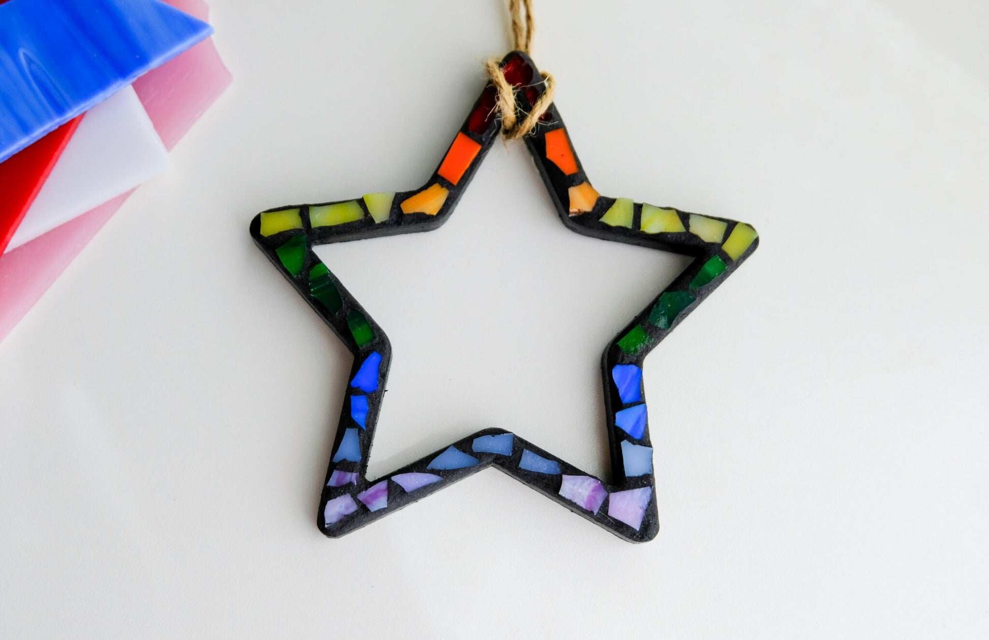 Rainbow Star stained glass mosaic ornament with black grout and a jute cord hanger